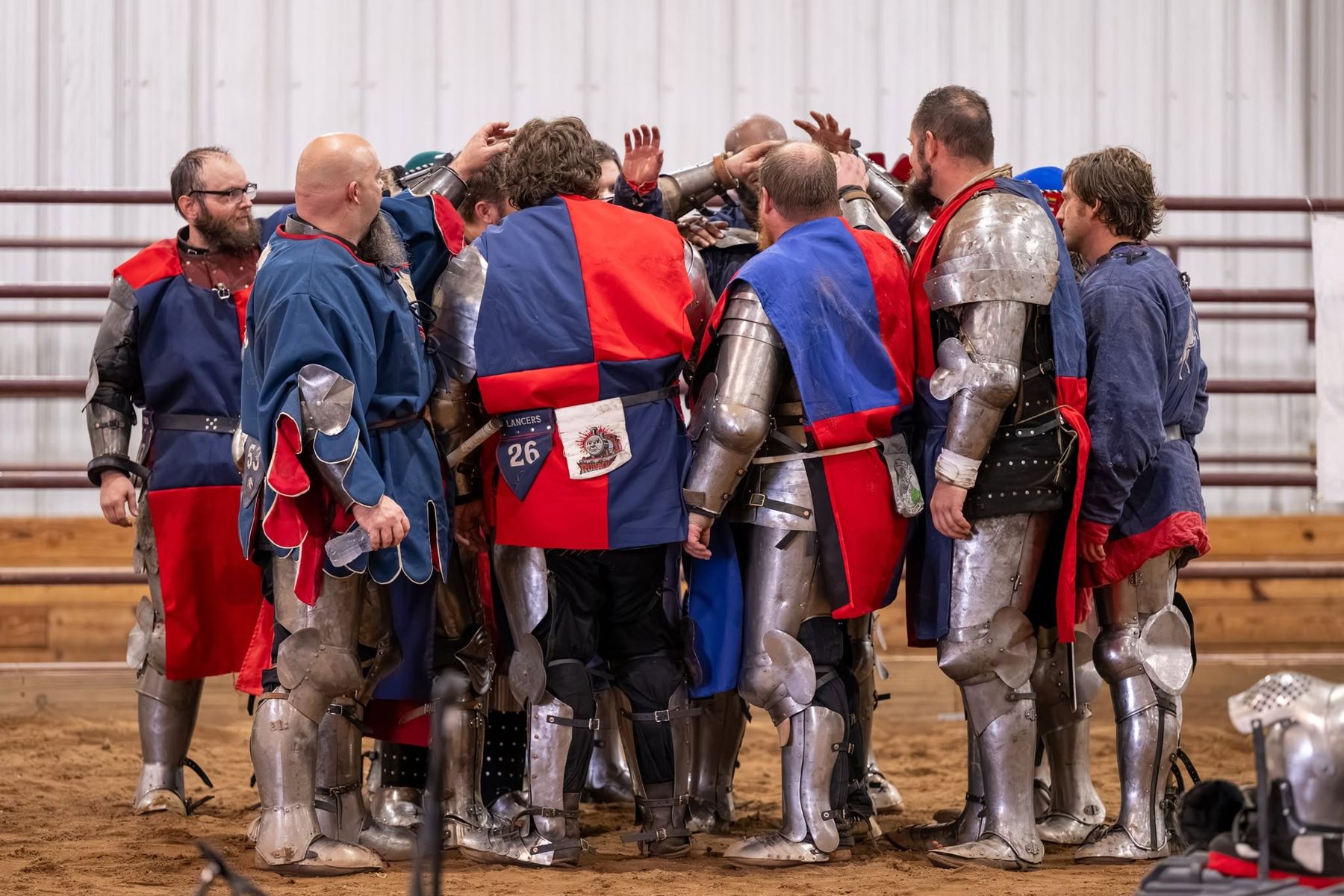 The team in a huddle, hands in, before a fight